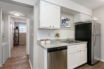 Renovated Kitchen with White Tile Backsplash and Stainless Steel Dishwasher and Fridge